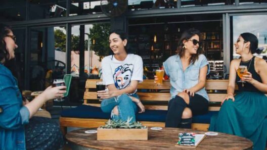 four women sitting on bench in storefront while drinking alcoholic beverages