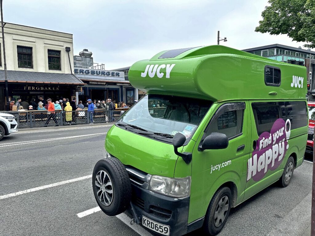 Jucy campervan in Queenstown, New Zealand, in front of iconic burger shop Fergburger